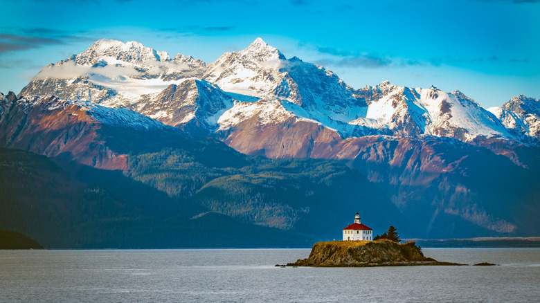 The Eldred Rock Lighthouse in Alaska with mountain views in the background.