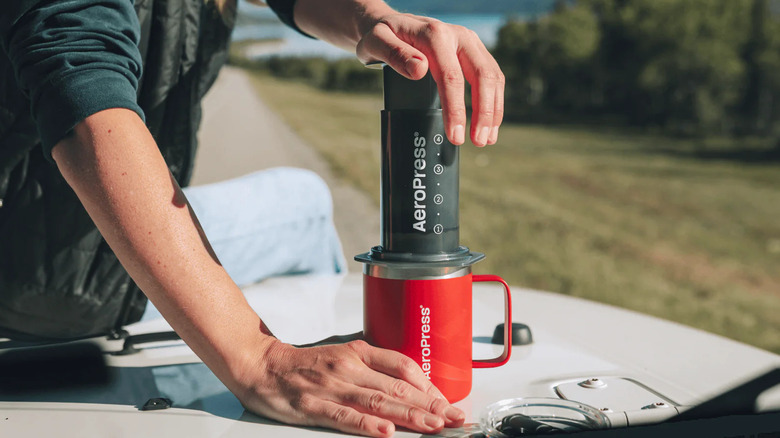Plunging a brew from the AeroPress Original while outdoors
