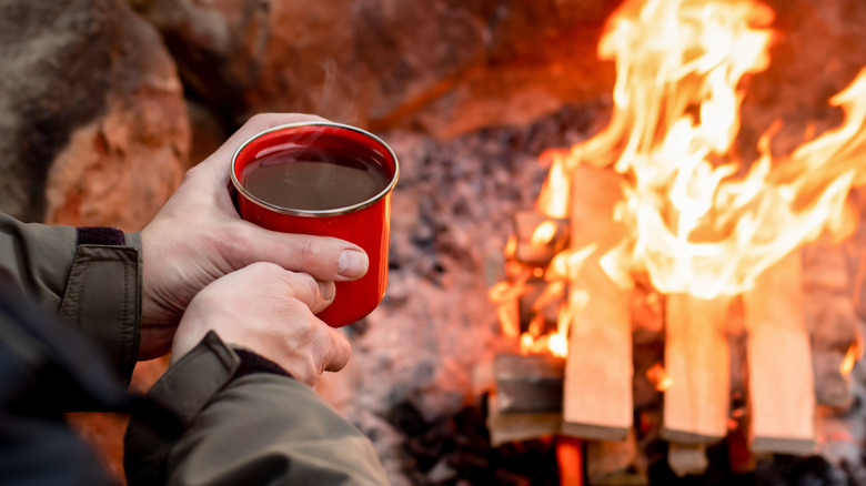 Enjoting a cup of coffee near a campfire