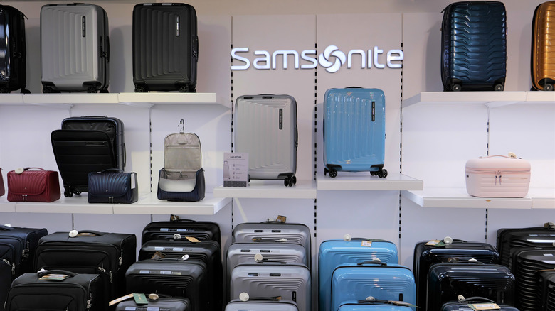 Samsonite display featuring grey, blue, and black suitcases as well as smaller travel caddies