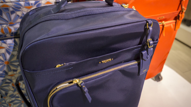 Close up of royal purple and orange Tumi brand luggage in a Tumi store in New York City