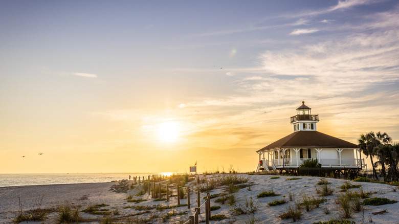 The historic Port Boca Grande Lighthouse and beach at Gasparilla Island State Park at sunset