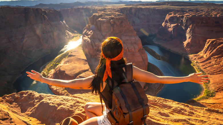 A woman admiring the breathtaking Horseshoe Bend and Colorado River.