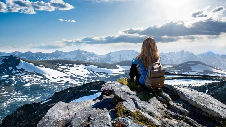 A woman enjoying landscapes of snow covered mountains at Rocky Mountains National Park.