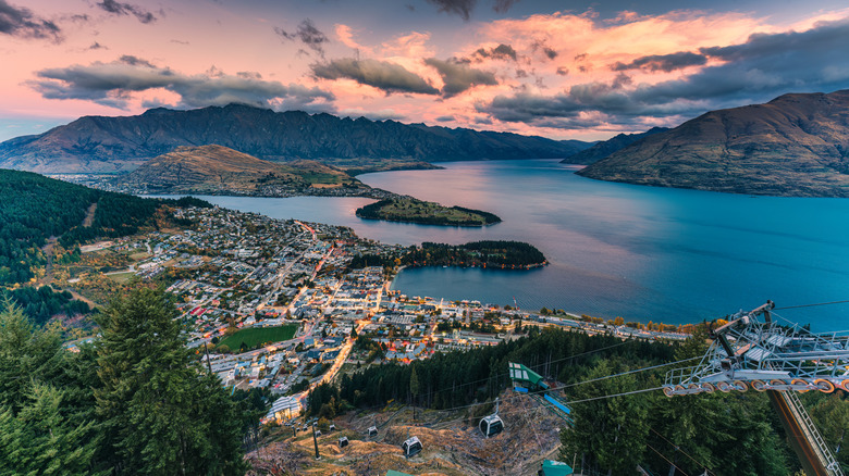 A beautiful sunset over an illuminated Queenstown in New Zealand.