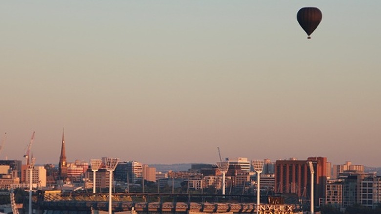 Black hot air balloon flying over Melbourne cricket ground