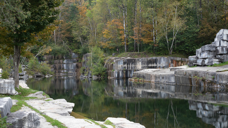 View of raw marble walls and scattered chunks of rock at the Dorset Marble Quarry, Vermont, in the fall