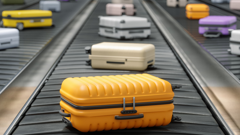 Array of colorful suitcases on airport baggage carousel conveyors