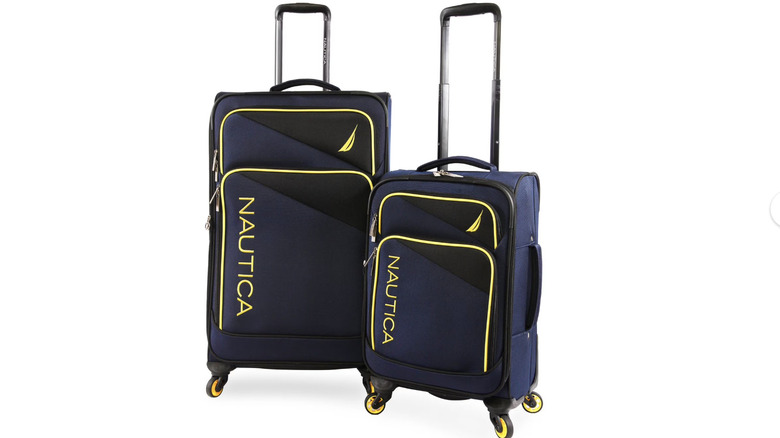 View of blue, black, and yellow Nautica Emry 21-Inch + 29-Inch Spinner Luggage Set on white background