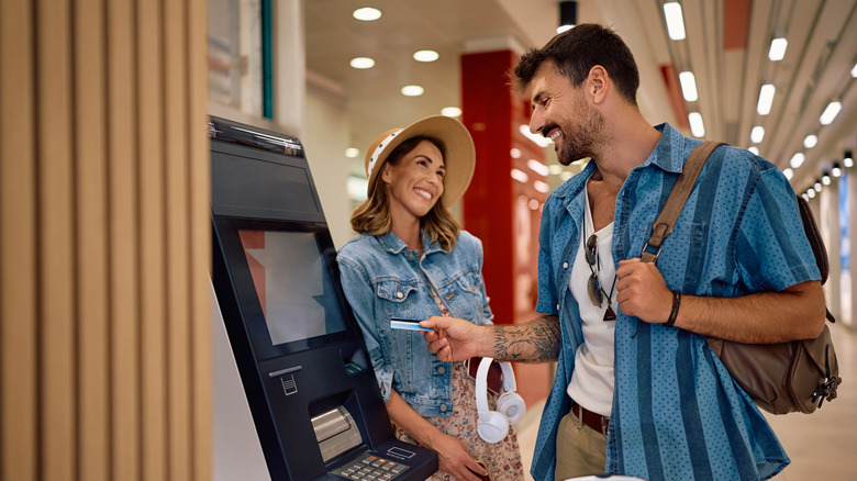 Couple at ATM while traveling