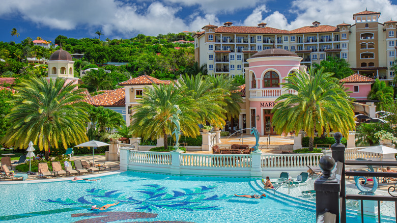 View of pool and palm trees at Sandals Grande Antigua Resort with hotel building in background