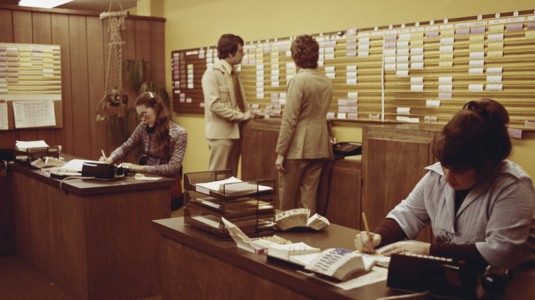 Two women working the phones at an airline ticket office in the 1970s.