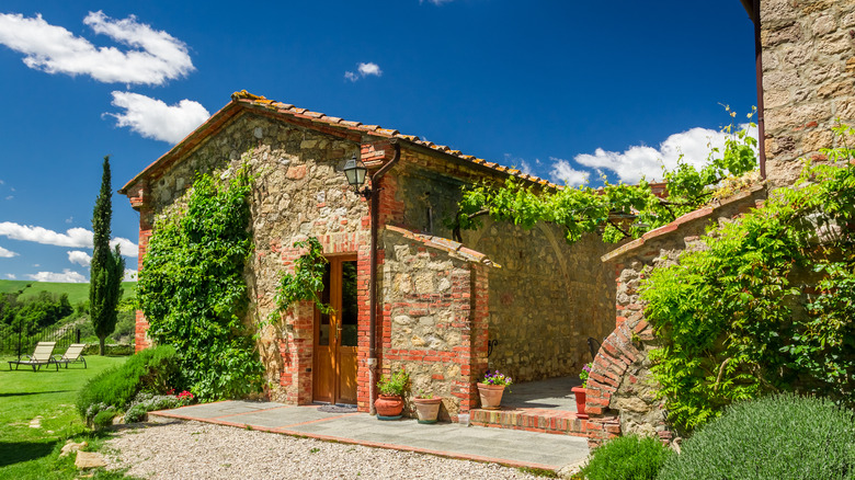 An old-world Italian villa on a sunny day with cyprus trees in the background