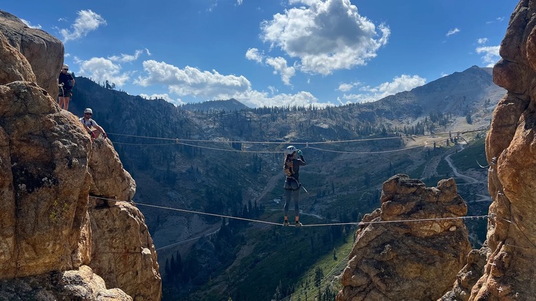 A woman traverses a fixed rope in a Via Ferrata course in Lake Tahoe