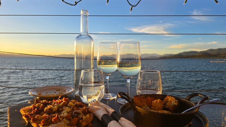 A spread of wine, water, and Italian tapas at sunset overlooking Lake Tahoe