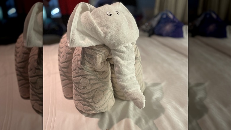 Close-up of elephant towel animal onboard Disney Cruise Line cruise ship stateroom with blurred background and Disney bag
