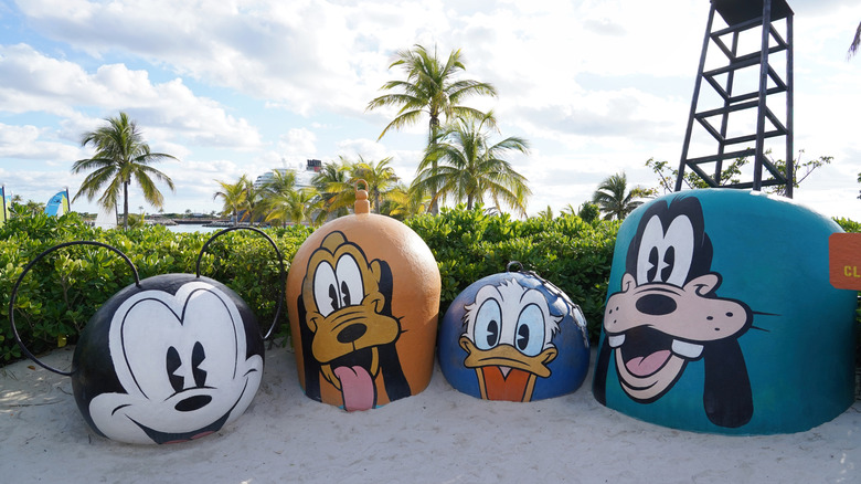Large concrete blocks painted with characters Mickey Mouse, Donald Duck, Goofy and Pluto line the beach at Disney Cruises private island Castaway Cay.