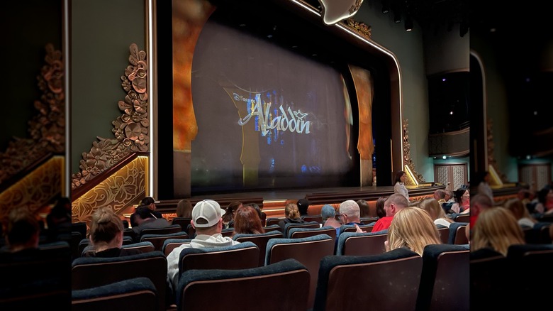 View of the ornate stage with 3D screen reading 'Disney's Aladdin' before a stage performance on the Disney Wish