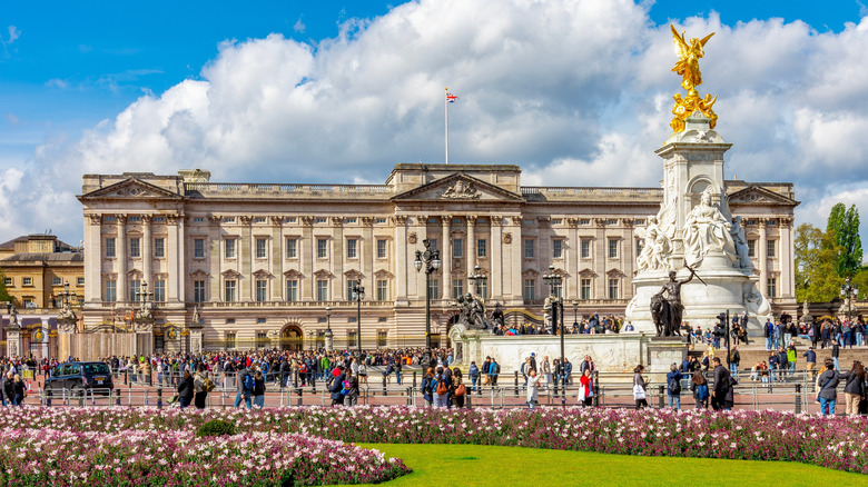 Gorgeous view of the Queen Victoria monument in front of Buckingham Palace with crowds of people
