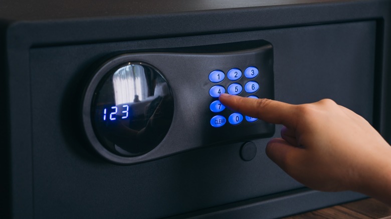 Someone putting a gun in their gun safe