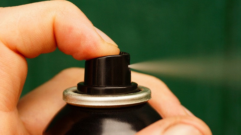 A hand holding aerosol hairspray