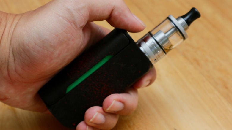 A hand holding a vape pen