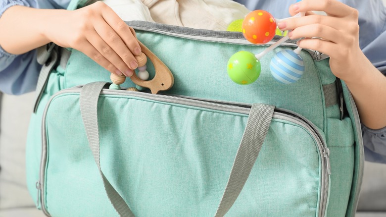 A person packing a diaper bag