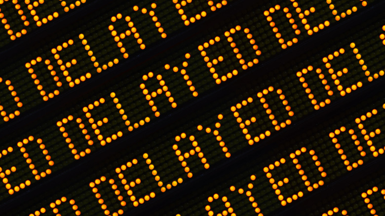 Airport style sign displaying the word "delayed" repeatedly