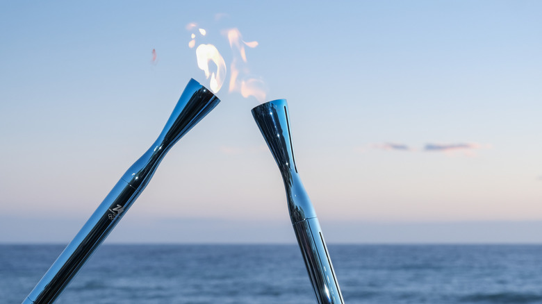 The Milan Cortina Olympics Torches passing fire during a relay