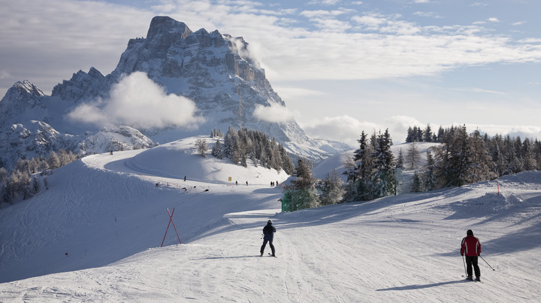 Skiers on a snowy slope in the Dolomites