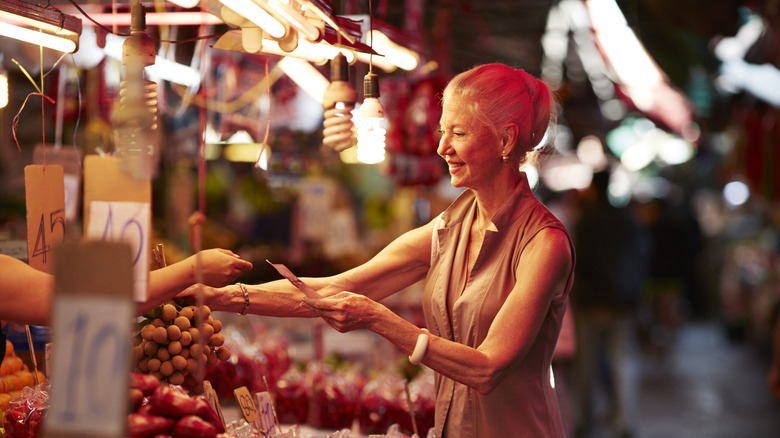 woman paying for fruit in market