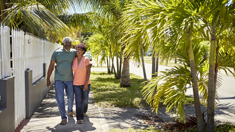 Full length view of Black couple in their 70s wearing casual clothing and approaching camera
