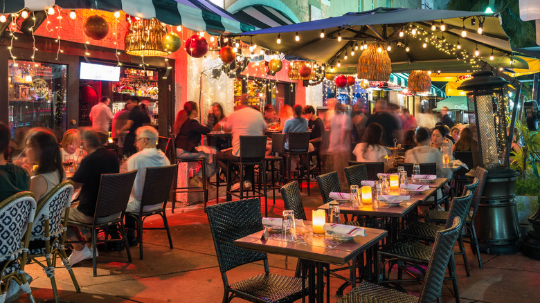 People dine on a restaurant patio on historic Espanola Way in Miami Beach
