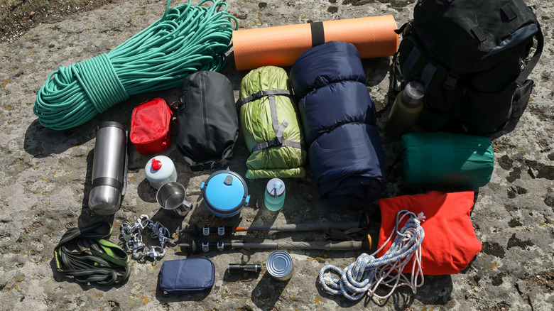 Backpack with hiking equipment pictured on a rock outdoors