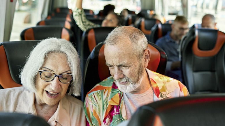 A senior man and woman enjoying a bus ride