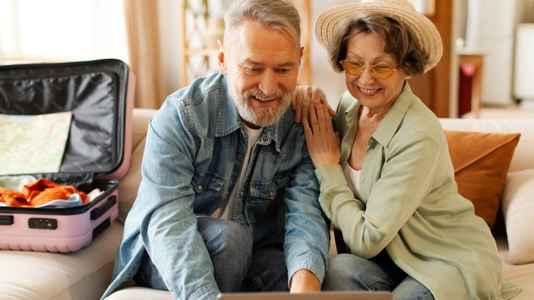 An older couple smiling while packing together