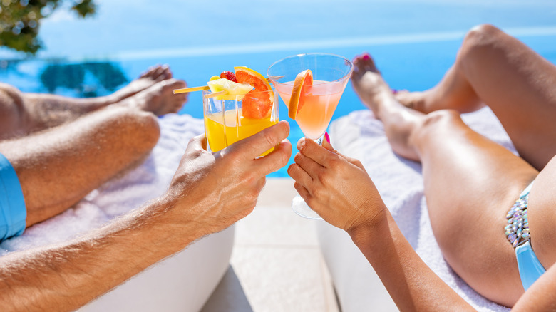 Couple drinking cocktails and relaxing by the sea.