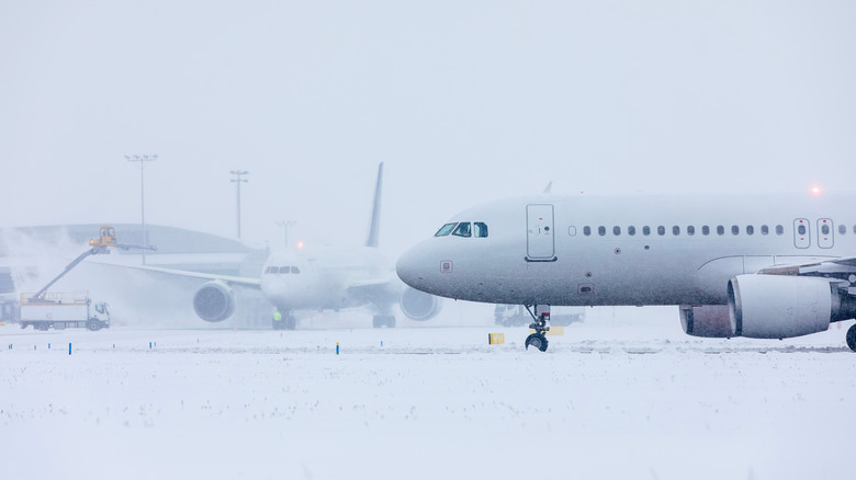 Winter frosty day at airport. Deicing of airplane before flight.