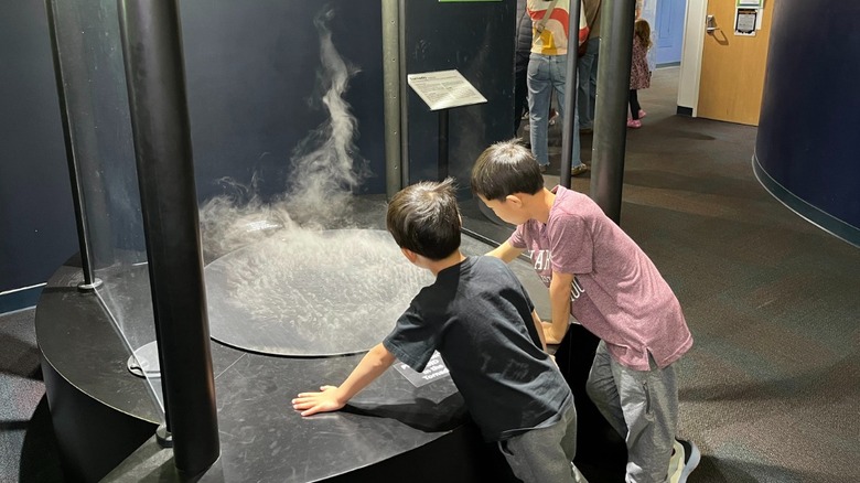 Two boys watch a tornado exhibit at the Discovery Center Museum in Rockford, Illinois.