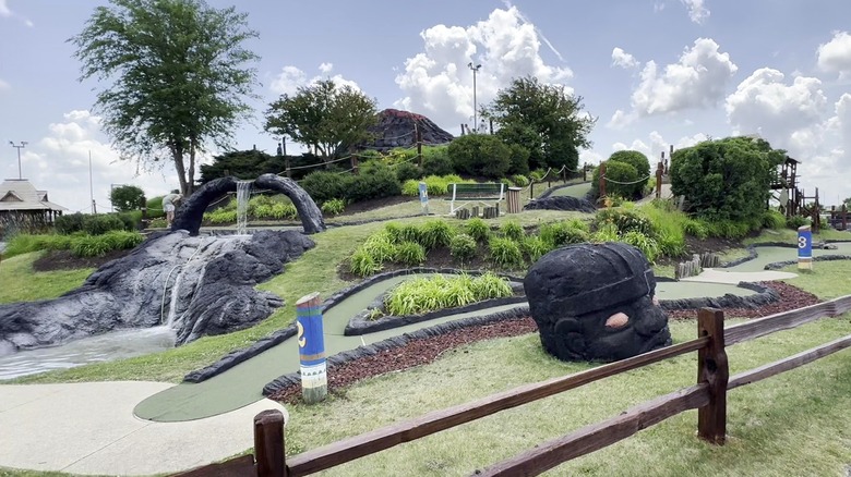 Waterfalls, grass, and volcanic rocks at Volcano Falls Adventure Park's miniature golf course.