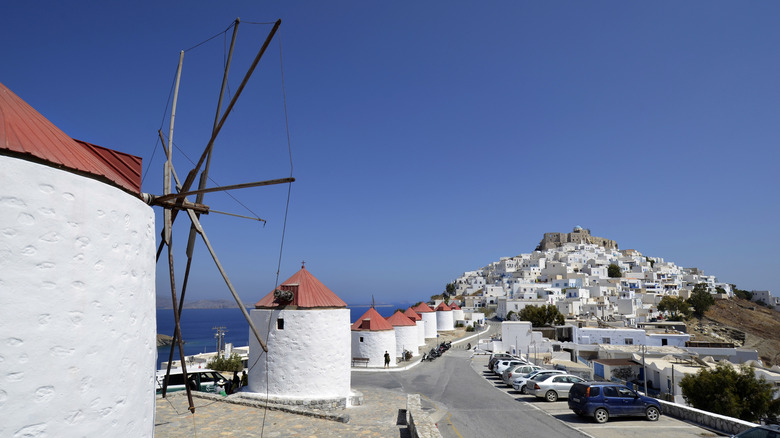 White town with windmills and old castle on the hill in the backdrop