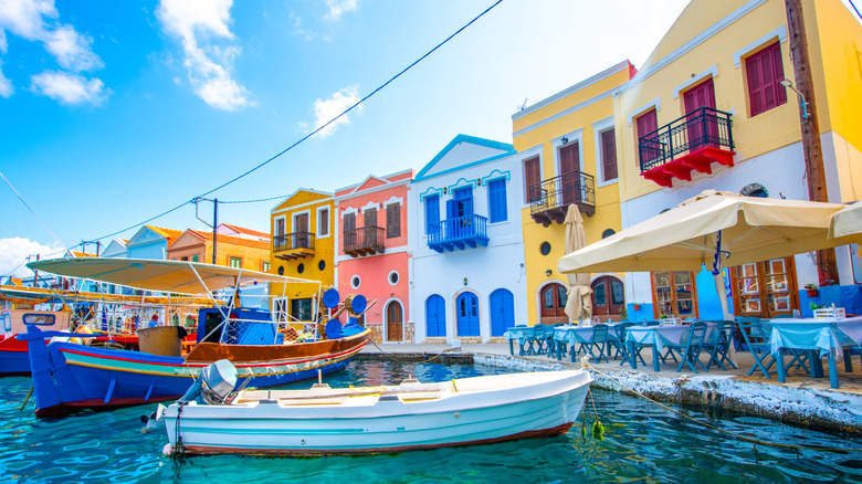 colorful neo classical houses overlook bright boats on the edge water, waterside cafe