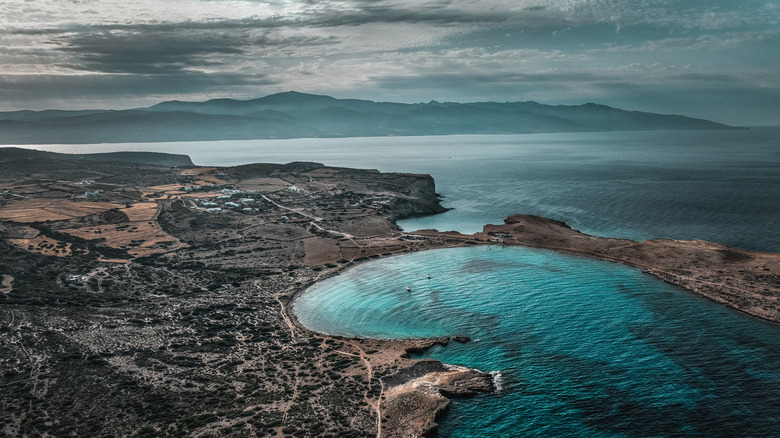 Aerial shot of a rocky island, turquoise waters, overcast skies