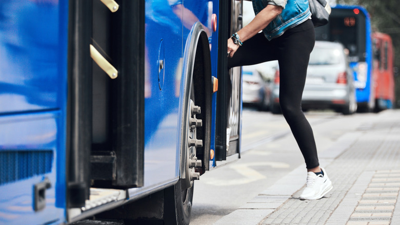 Person getting on blue bus