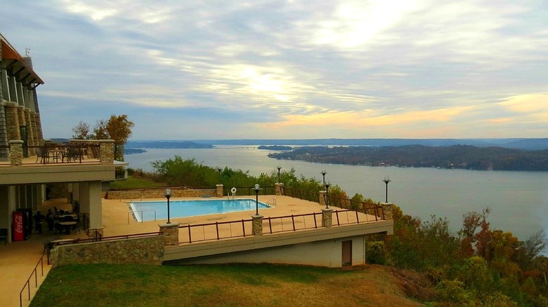 A hotel pool next to a building with a deck overlooking Guntersville Lake
