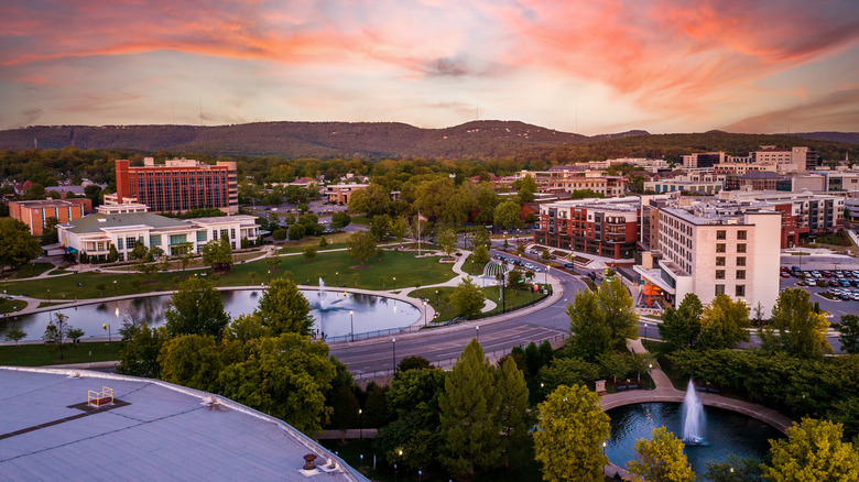 A view of downtown Huntsville, Alabama, against a pink sky near sunset with hills in the background