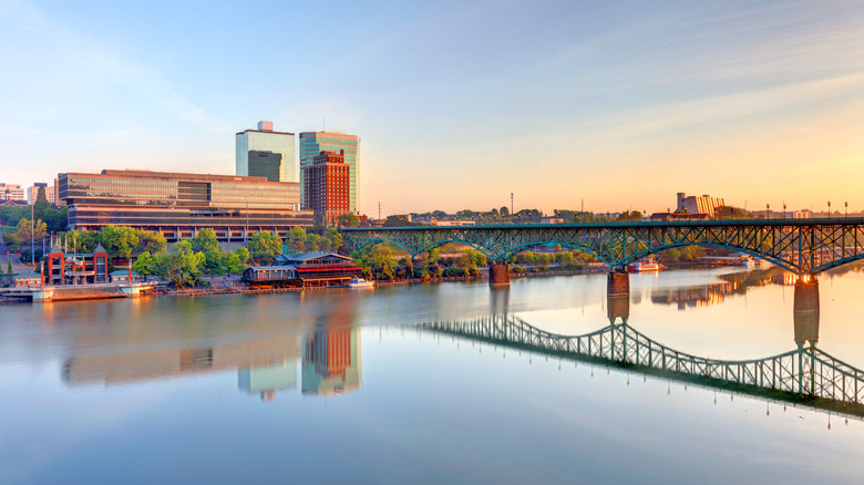 A bridge reflected in the river that leads to buildings in Knoxville, Tennessee