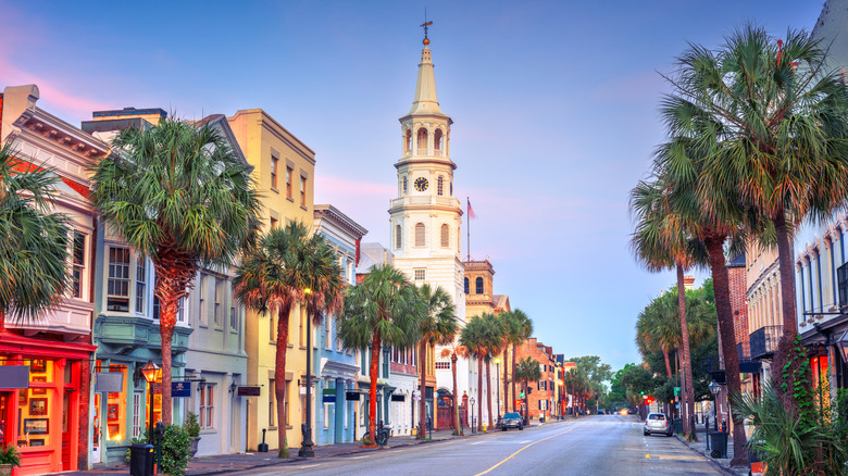Cityscape of Charleston, South Carolina with palmetto trees and colorful lined shops on both sides of the street