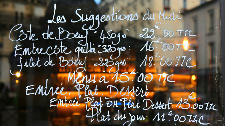 Menu with prices written on a bistro window in Paris