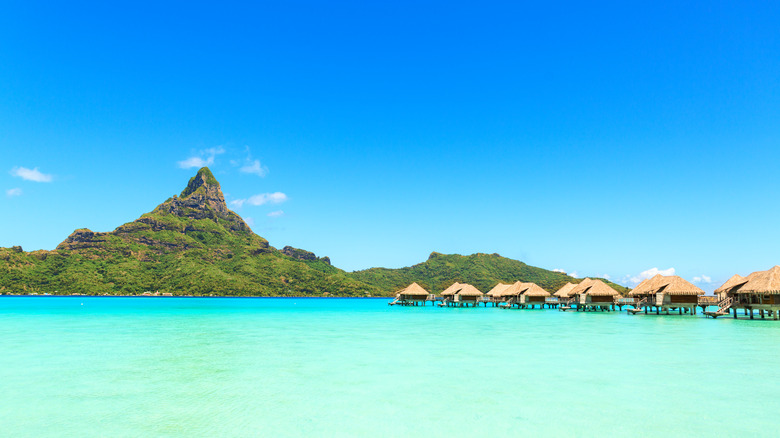 View on Mount Otemanu through turquoise lagoon and overwater bungalows on the tropical island Bora Bora
